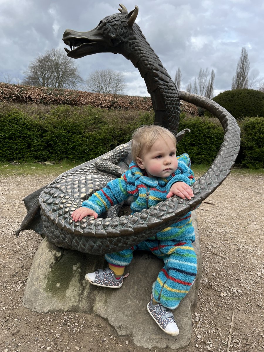 A young child next to the Dragon sculpture