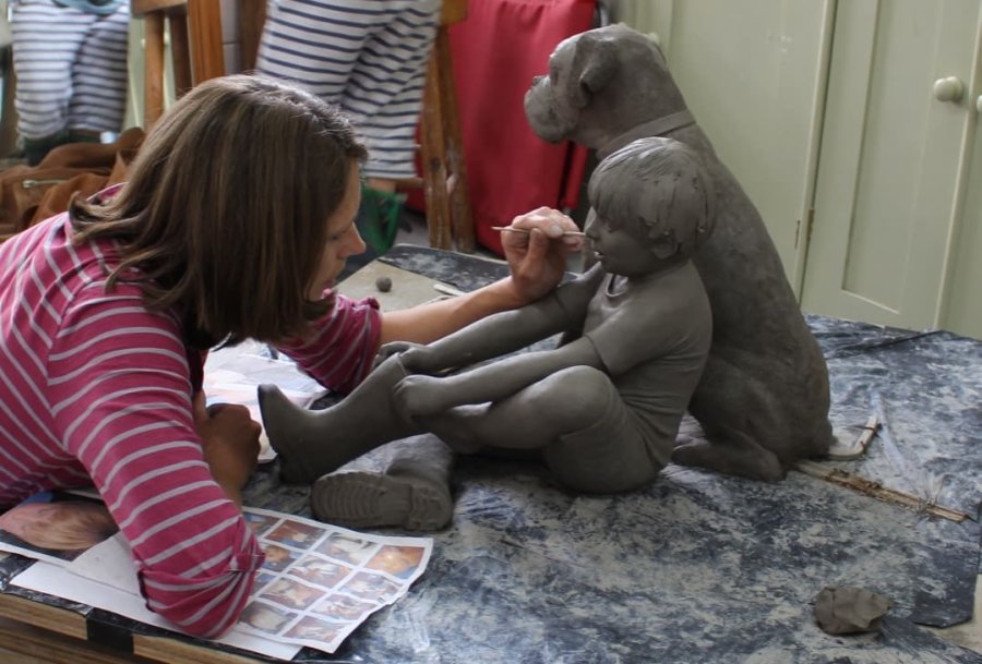 Hannah working on Boy and Boxer Dog clay sculpture