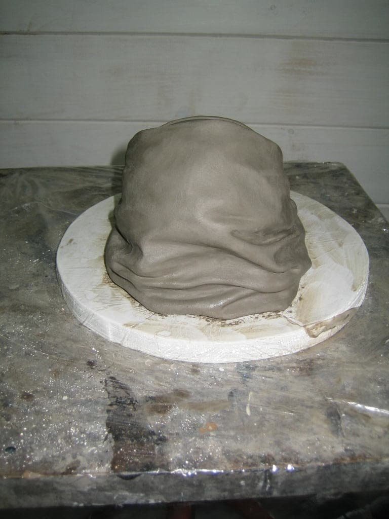 A clay sculpture of a baby from the back