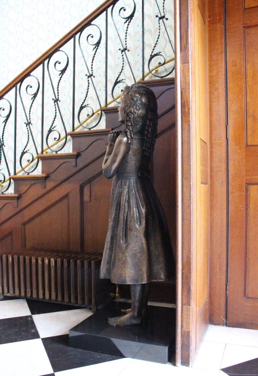 Bronze statue of a sister by a staircase