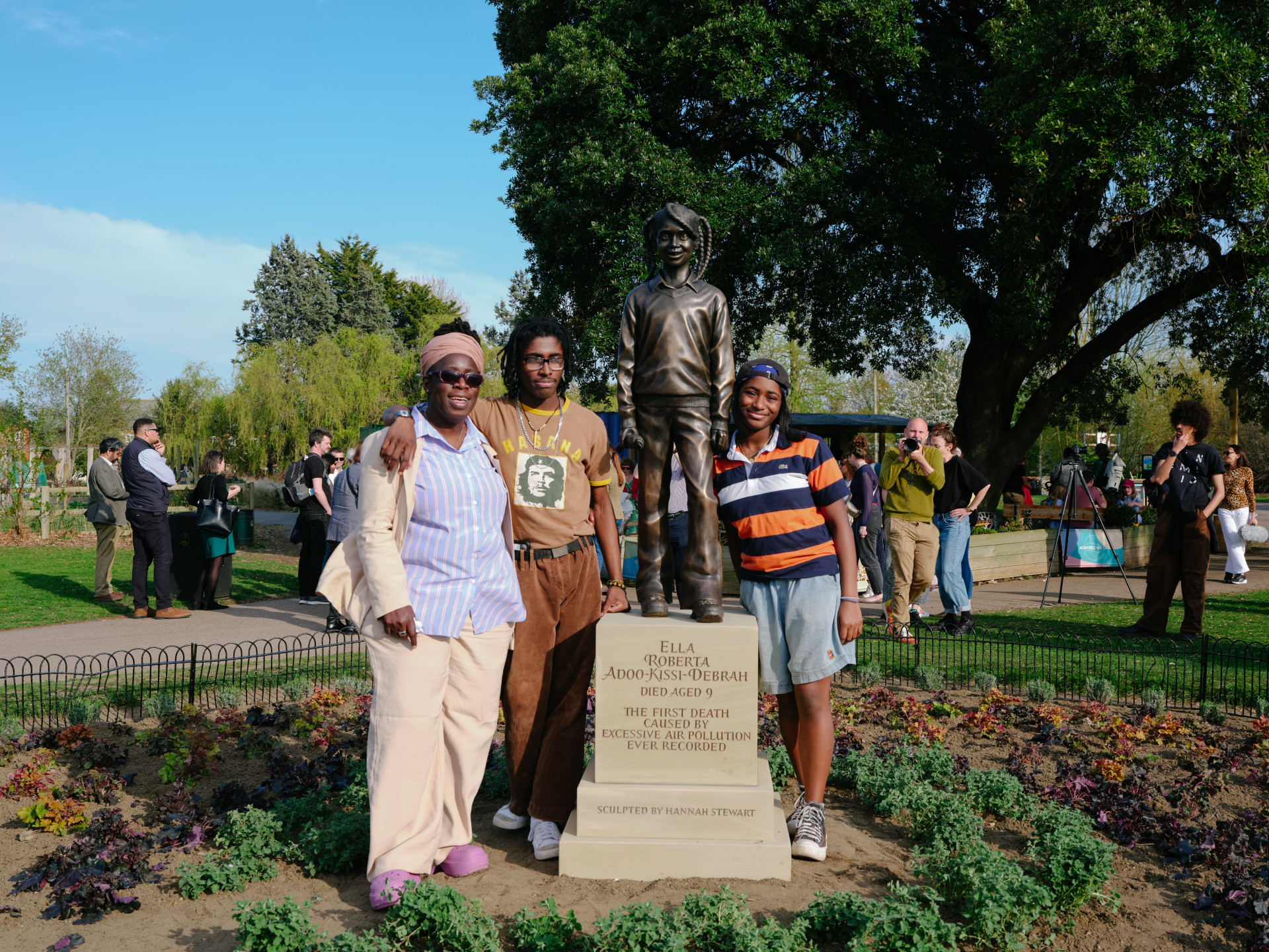 Ella's family standing next to the bronze statue of Ella